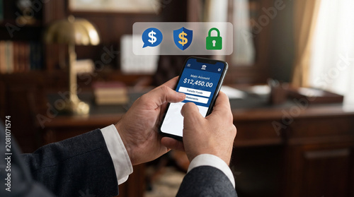 A professional person in a formal suit holds a modern smartphone displaying a mobile banking application with secure digital icons floating above the bright screen.