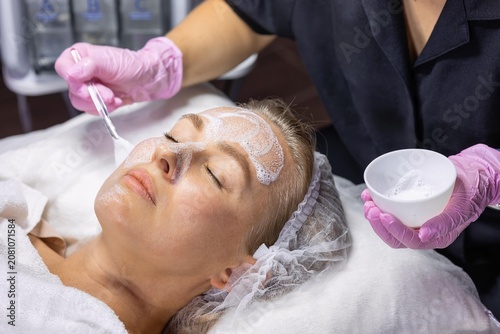 Photos Cosmetologist applying foaming facial cleanser before professional skincare treatment