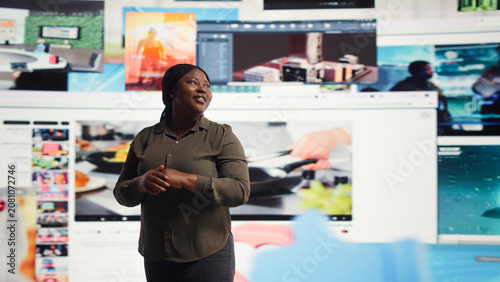 Tableau sur toile Woman reacts with amazement to a digital wall filled with streaming videos and social media clips for modern entertainment