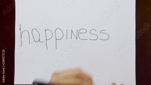 Hands Writing Happiness on White Paper Over Brown Wooden Table Top View