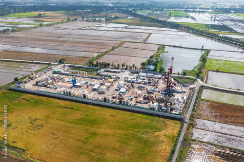 Fotografie Aerial View of Land Drilling Rig and Oilfield Facility in Rice Fields