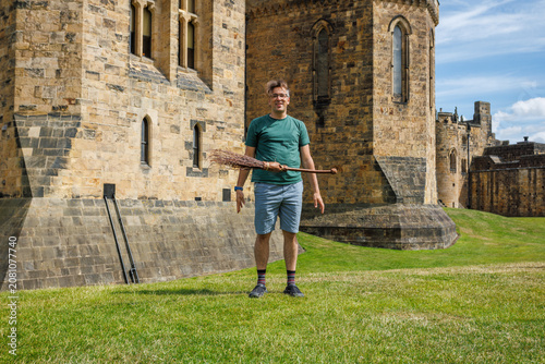 Photos Man have fun pretending make fly broomstick in front of a castle