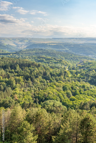 Layers of green mountains and hills in the haze during sunset. Panoramic View of Green hills and Meadow.