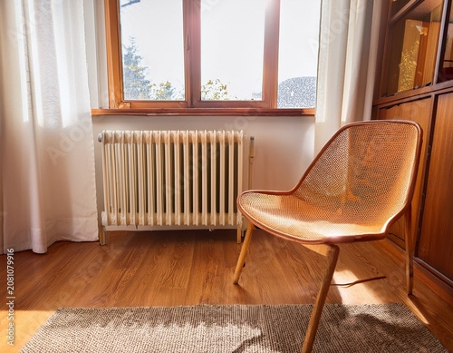 sunlit mid century chair beside radiator in a quiet warm room