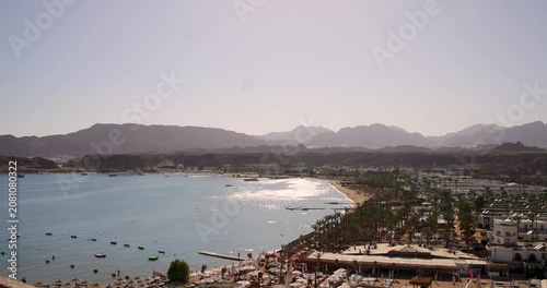 Elevated view of Sharm El Sheikh Egypt showing luxury Red Sea resorts palm lined beaches and dramatic Sinai mountain scenery in a popular holiday destination on a hot sunny summers da