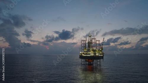 Aerial view of offshore jack up rig and offshore platform during sunset for oil and gas exploration and production. 