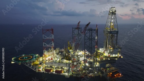 Aerial view of offshore jack up rig and offshore platform during sunset for oil and gas exploration and production. 