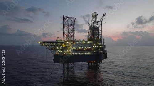 Aerial view of offshore jack up rig and offshore platform during sunset for oil and gas exploration and production. 