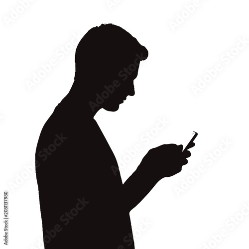 Silhouette of a young man using a mobile phone device