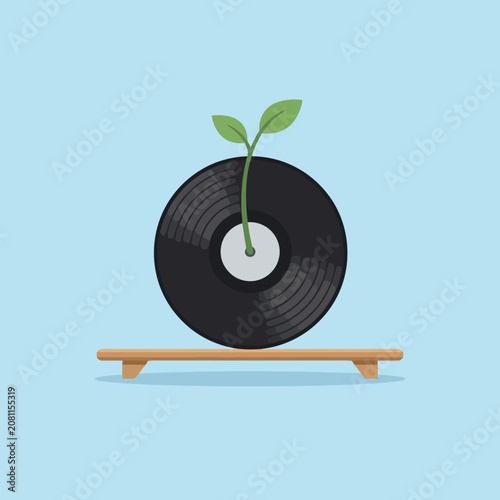 A small green plant grows from a black music record disc