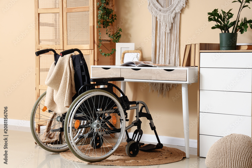Fototapeta premium Wheelchair next to desk in cozy home interior
