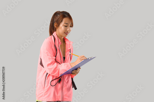 Female Asian PE teacher wri...