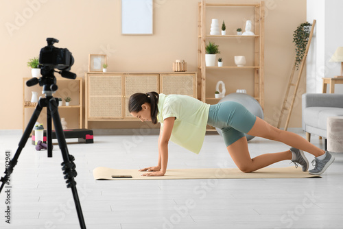 Sporty female blogger exerc...