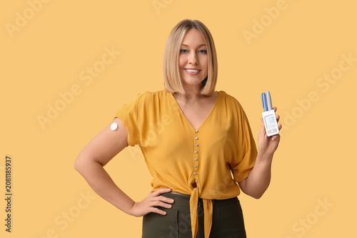 Bild auf Leinwand Woman with blood sugar sensor and glucometer on yellow background