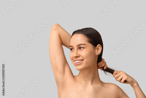 Billede på lærred Young dark-haired woman on grey background