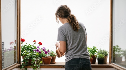 Photorealistic person from behind, no face, watering flowers on windowsill, soft lighting, pure white studio background