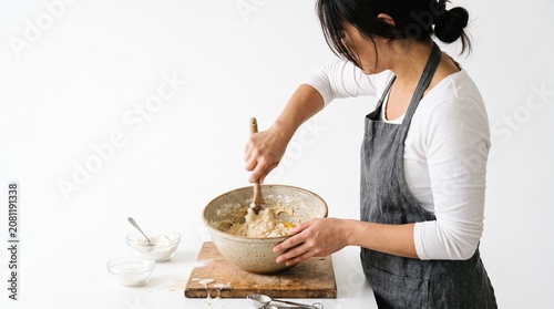 Photorealistic person from side, no face visible, mixing ingredients in bowl, cooking action, pure white background