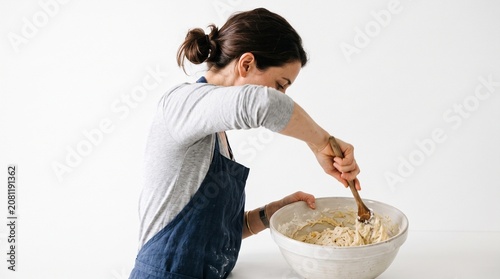 Photorealistic person from side, no face visible, mixing ingredients in bowl, cooking action, pure white background