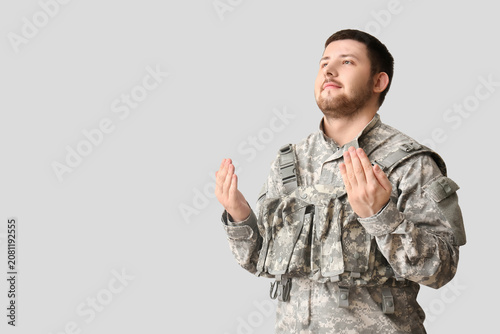 Fotografija Male Jewish soldier praying on light background