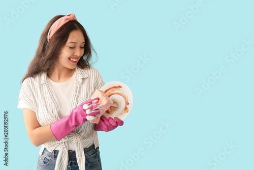 Young woman washing plate o...
