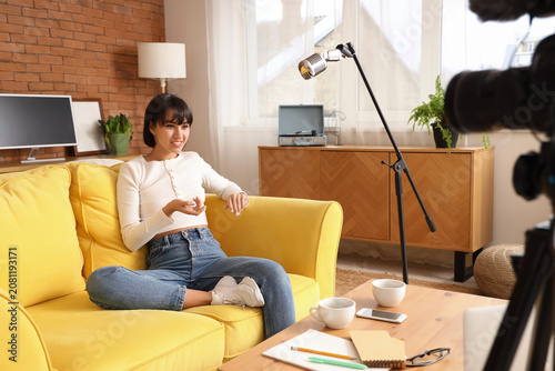 Young woman recording podcast at home