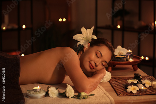 Young woman lying in dark spa salon