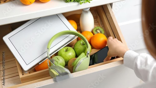Woman Putting Phone in Drawer with Food and Gadgets