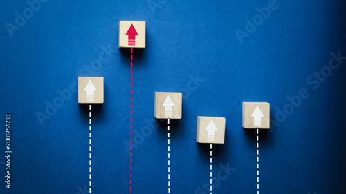Schilderij op canvas Wooden blocks with upward arrows on a blue background symbolize business growth,