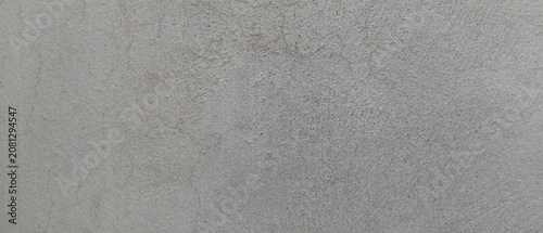 Industrial gray concrete texture background, weathered cement wall surface with subtle cracks, minimalist stone plaster finish for architectural design