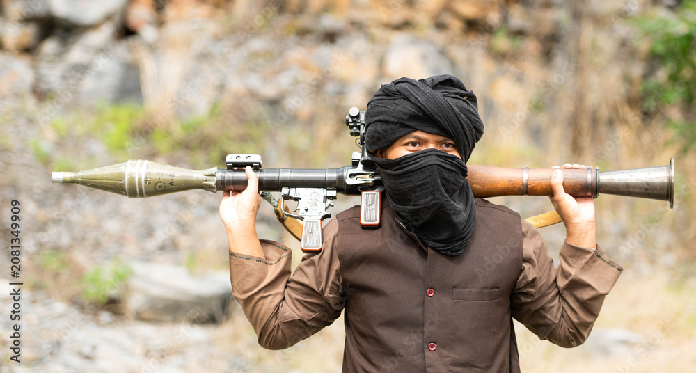 Fototapeta premium Armed insurgent carrying a rocket launcher during a military conflict simulation