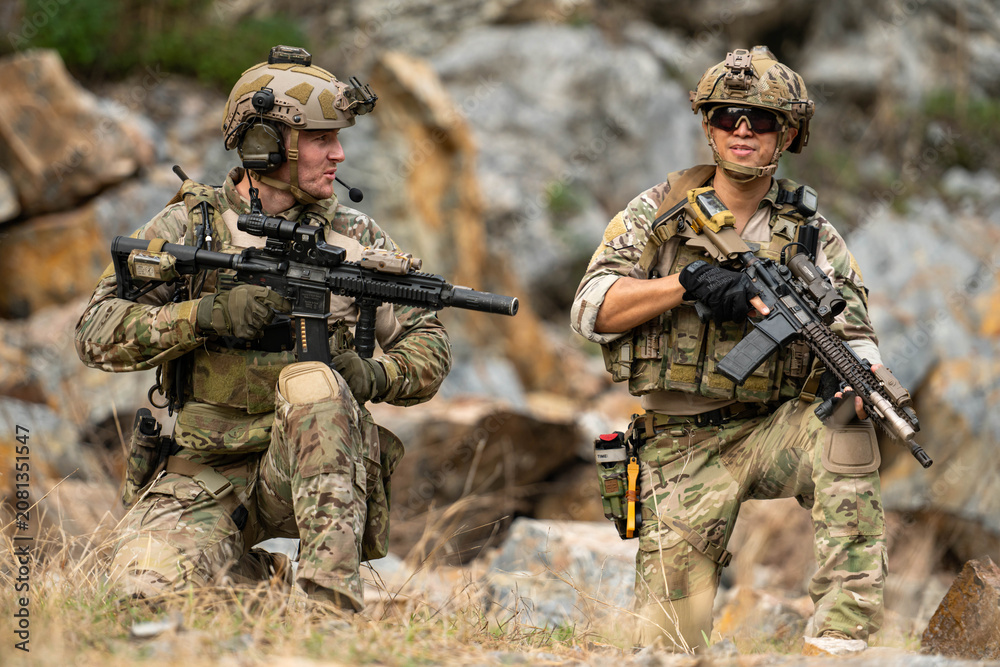 Fototapeta premium Military personnel communicate and coordinate during a tactical field operation