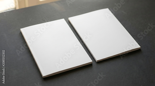 Two blank white notebook covers on a dark textured surface for professional business branding mockups and stationery designs