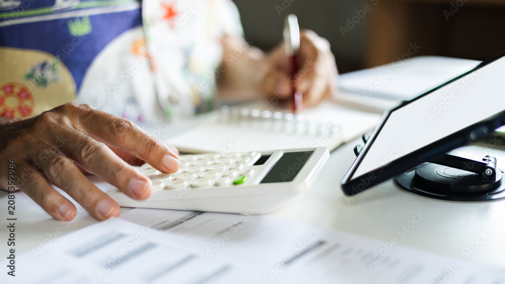 Fototapeta premium close-up shot, casual man working at home using wireless technology to start new business online, E-commerce via digital tablet, calculate business cost