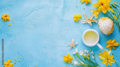 Summery flatlay featuring yellow flowers, seashells, and a beverage in a white mug against a light blue background