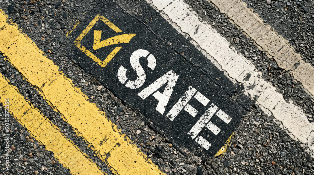 Fototapeta premium Safe road sign painted on asphalt, safety concept with checkmark symbol on street pavement, secure traffic and transportation background