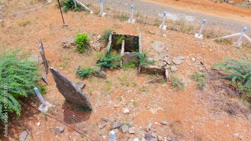 Top-down aerial shot of Kodumanal megalithic site, Tamil Nadu, ancient menhir standing stones and stone cist burial chambers set against striking red soil, a rare Iron Age heritage site.