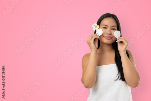 Foto Woman enjoys skincare routine holding items in hands