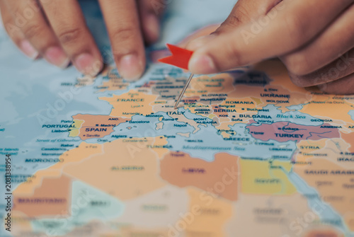 Woman highlights italy on a map preparing for an exciting travel adventure across europe
