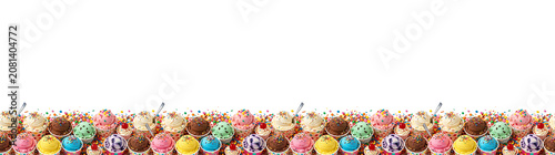 Assortment of colorful ice cream scoops in paper cups with sprinkles and candy scattered on a whit