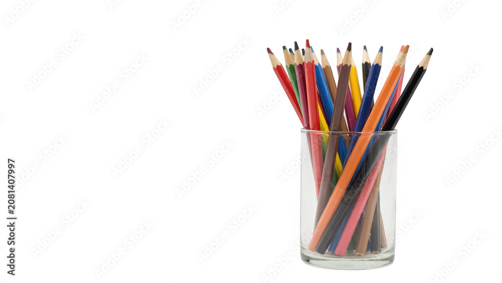 Fototapeta premium A collection of sharpened colored pencils standing upright in a clear glass container isolated against a solid black background, for contrast