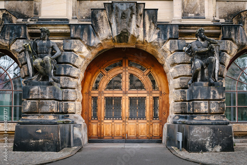 Historic Baroque Stone Entrance with Monumental Sculptures and Ornate Wooden Doors in Dresden