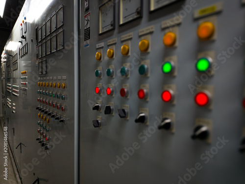 Close-up photo of industrial electrical control panel with buttons, switches, and gauges. Perfect for engineering, factory, and technical design themes.