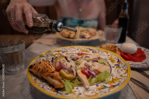 przyprawianie sałatki cezar oliwą w restauracji