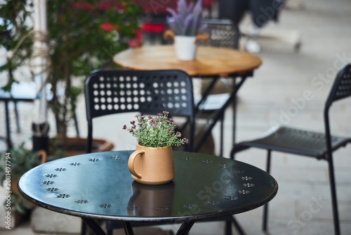 Mug with flowers, decor on a table in an outdoor cafe