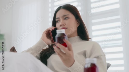 Asian woman checking on medicine bottle at home