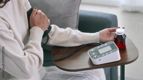 Female  monitoring blood pressure at home
