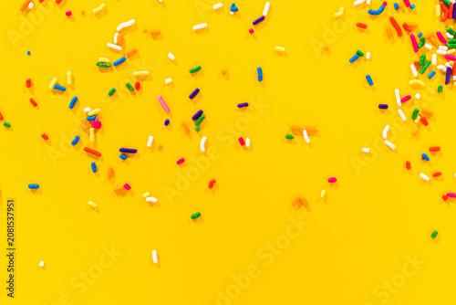 Картината върху платно Evenly spaced sprinkles over yellow surface