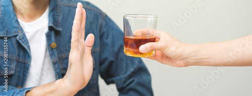 Obraz na plátne Alcoholism, depressed asian young man refuse, push out alcoholic beverage glass, drink whiskey, sitting alone at night