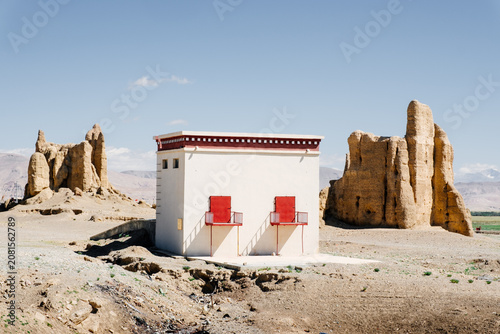 Schilderij op canvas Local Tibetan villagers have built barns with modern materials among the centuries-old clay fortress ruins, creating a striking contrast between the old and the new