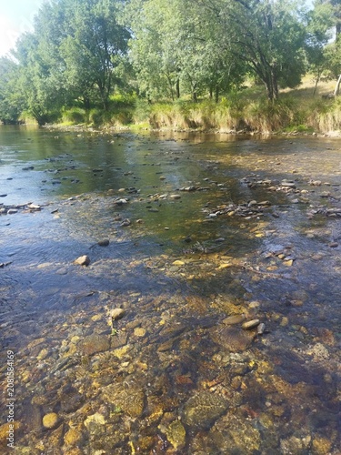 Agua cristalina y fondo de piedras en la piscina natural de Hoyos, Sierra de Gata, Cáceres, Extremadura, España.